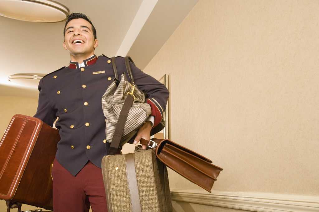 Hotel bell hop carrying luggage