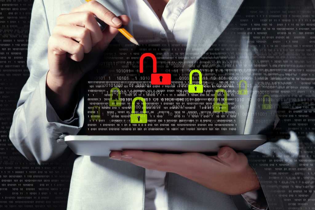 Female executive holding mobile tablet with security icons floating above