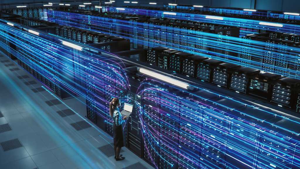 image of Woman holding laptop in data center